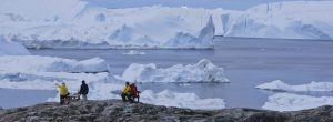 Tourists looking at huge icebergs on the arctic ocean