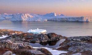 Tourists looking at huge icebergs on the arctic ocean