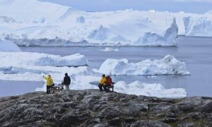 Tourists looking at huge icebergs on the arctic ocean